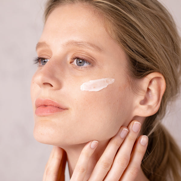 Gesicht einer Frau in Nahaufnahme mit einem Streifen der Tagescreme von UNYK Cosmetics auf der Haut. Die schnell einziehende Power-Emulsion ist eine ideale Grundlage für ein strahlendes Make-Up.